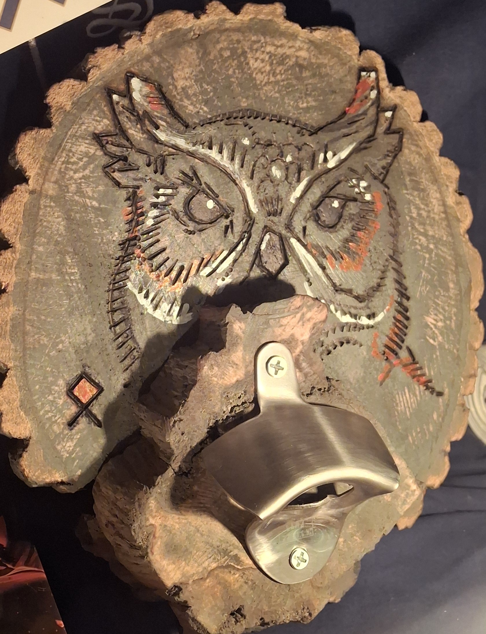 Handcrafted owl design on a natural wood slice with a metal bottle opener