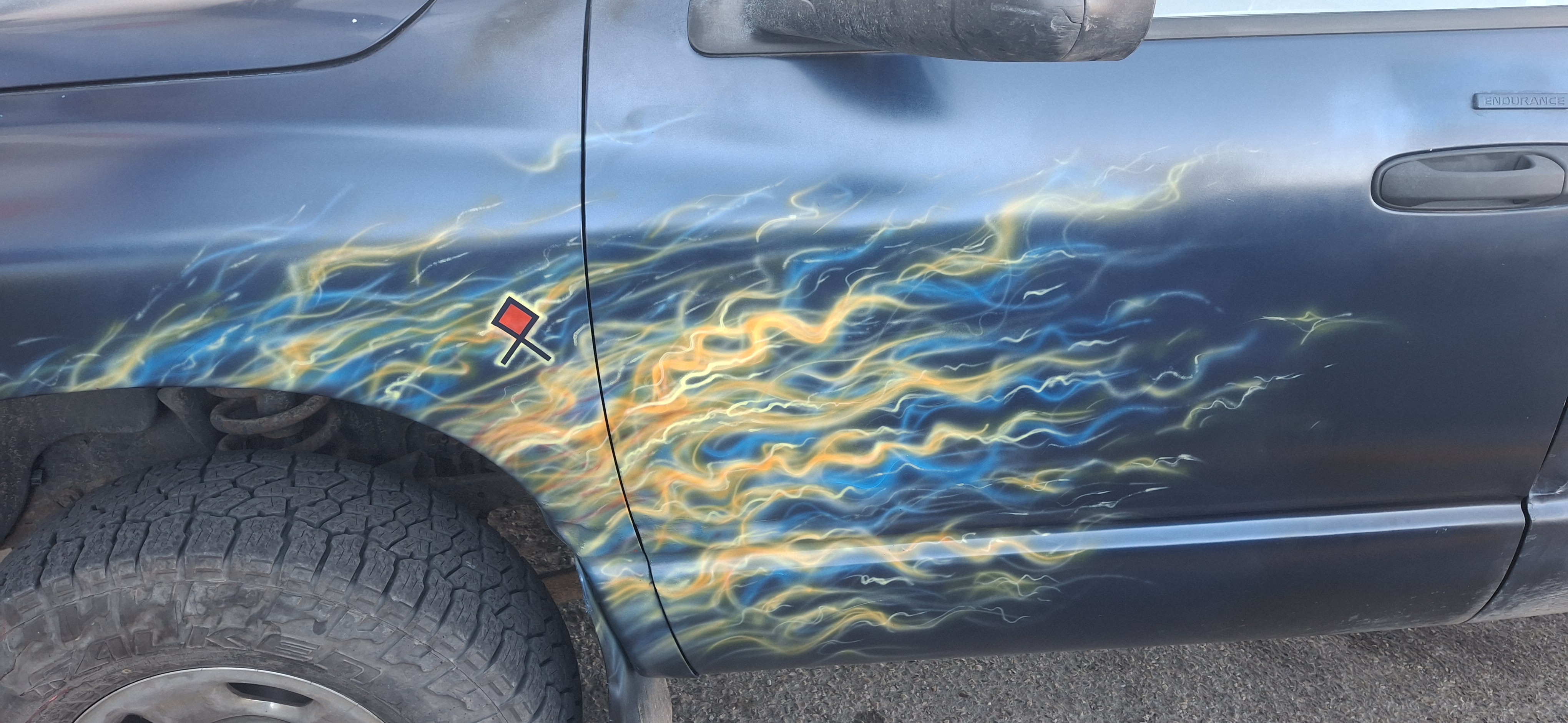 Blue and gold airbrushed flames across the truck's driver-side door and front fender
